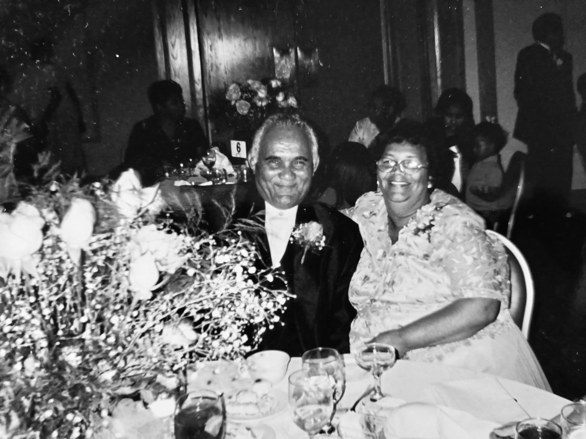 Maria and Moises at a banquet table with flowers