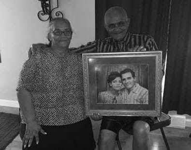 Maria and Moises holding a framed portrait